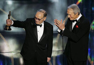 Morricone salutes his wife with presenter Clint Eastwood